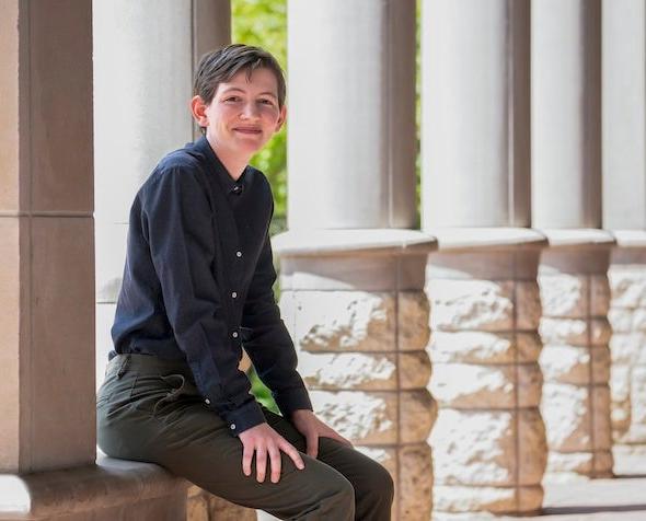 Flynn sits in front of stone columns.