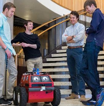 Students gather around a robot they built