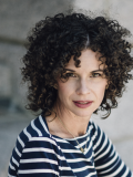 A photo of Erin Willer, a woman with dark curly hair and a blue and white striped shirt